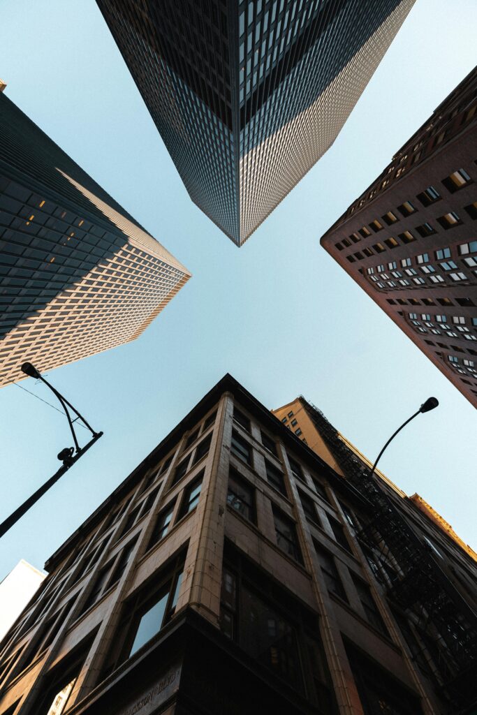 Dynamic view of Chicago skyscrapers from street level, highlighting modern architecture and a clear sky.