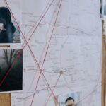 Investigative bulletin board with maps, photos, and red threads connecting clues.