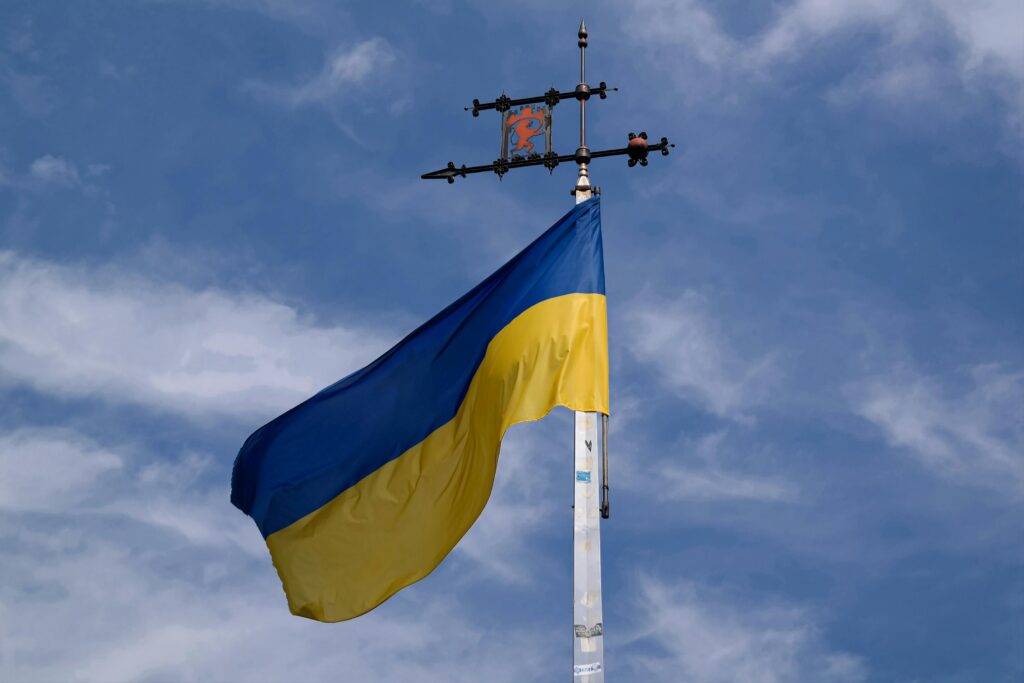 The Ukrainian flag billows proudly against a clear blue sky, representing national pride.